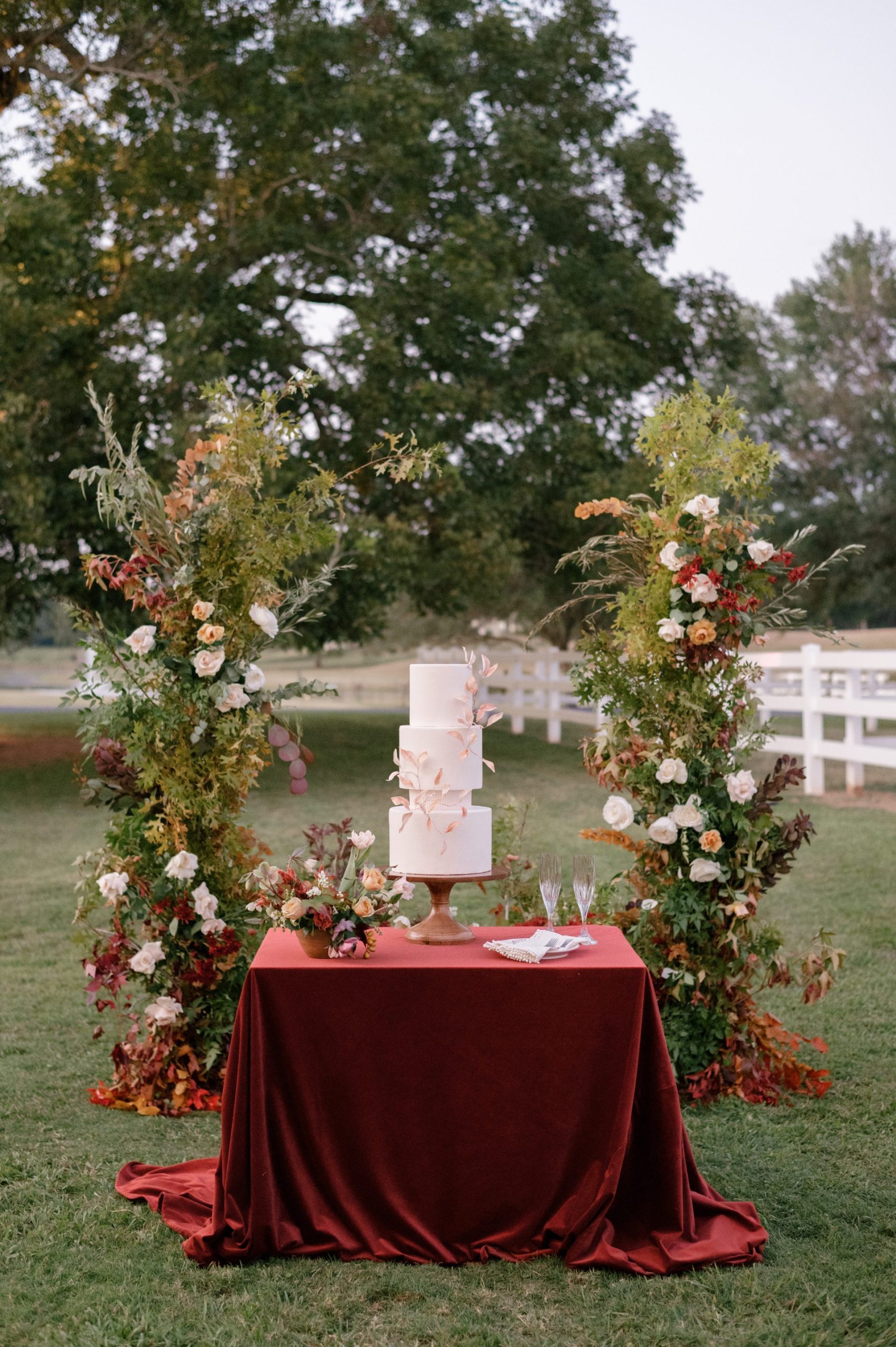 3 tier wedding cake with floral arch